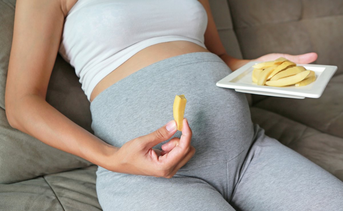Pregnant woman eating mango
