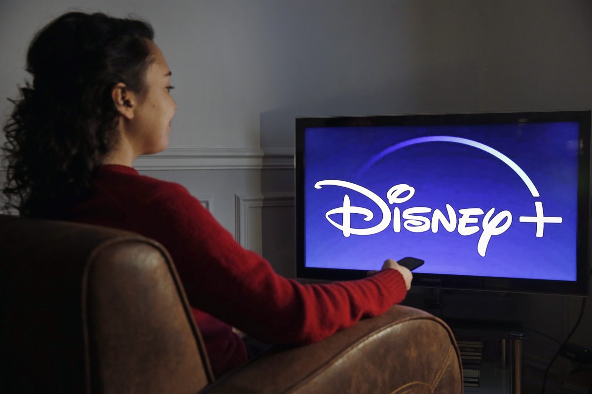 Woman sitting in front of Disney+ screen