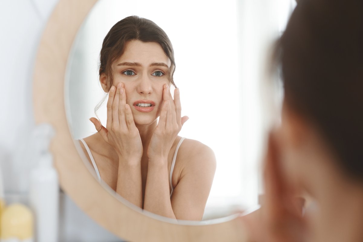Stressed young person looking in the mirror