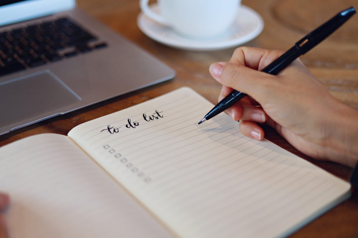Hand writing to-do list in a notebook.