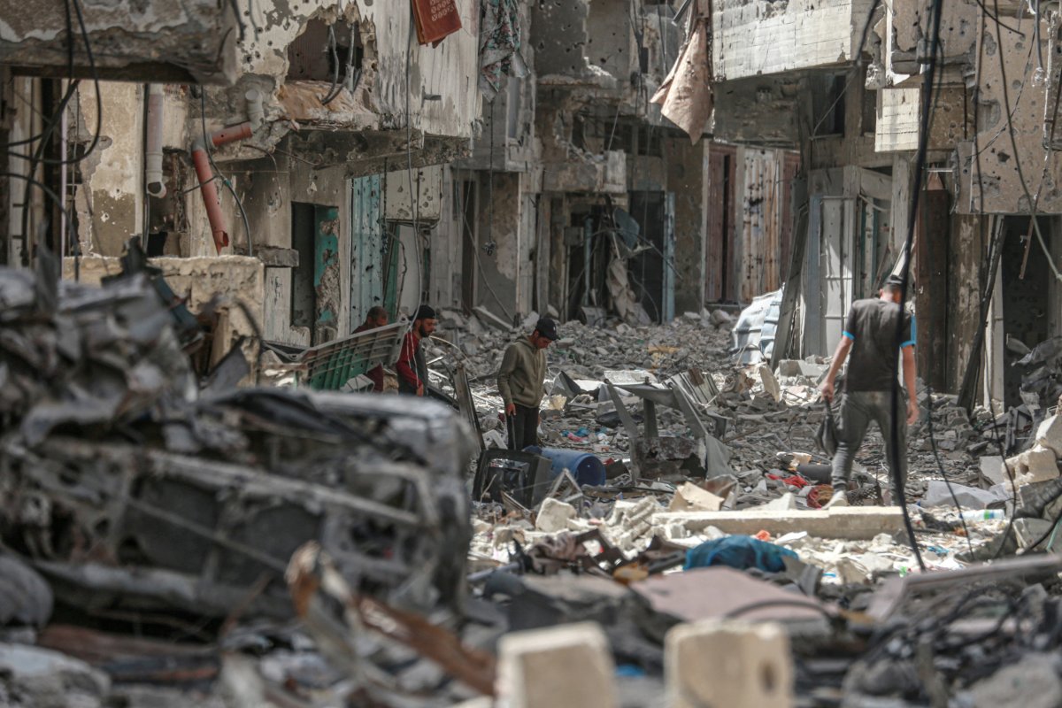 Palestinians walk among building rubble 