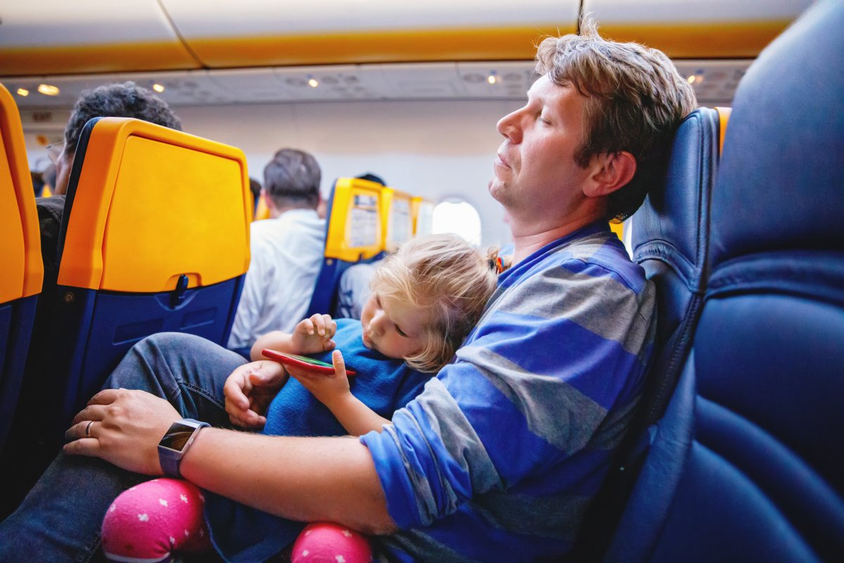 Man on plane with child in lap.