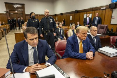 Trump seated between attorneys