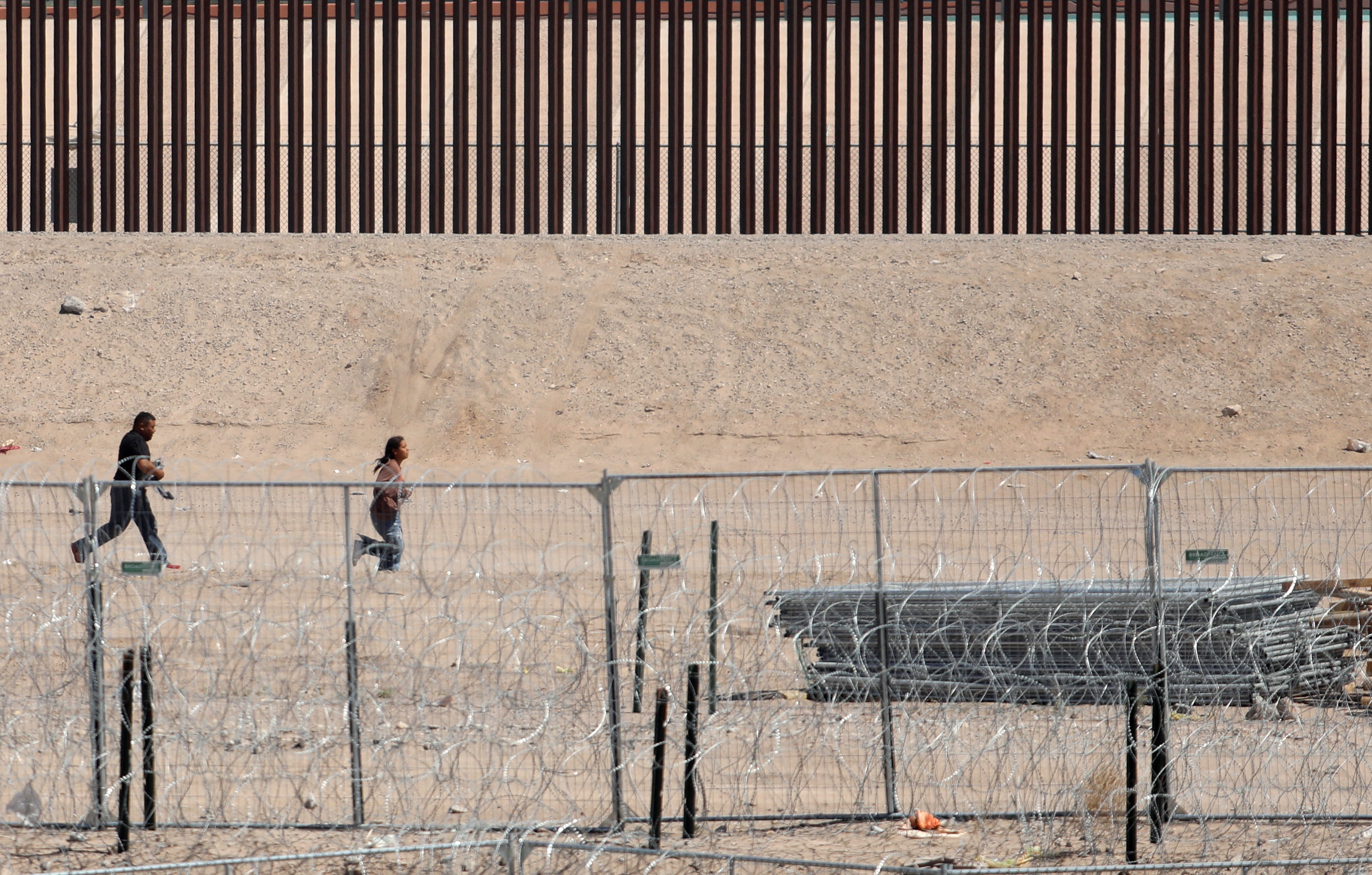 Video Shows Migrants Rush Border Wall, Try to Climb Over - Newsweek