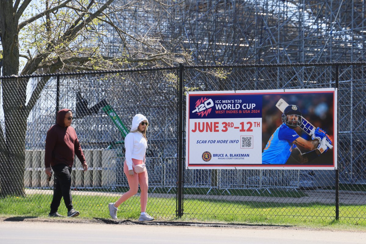 People walk by Nassau County NY cricket