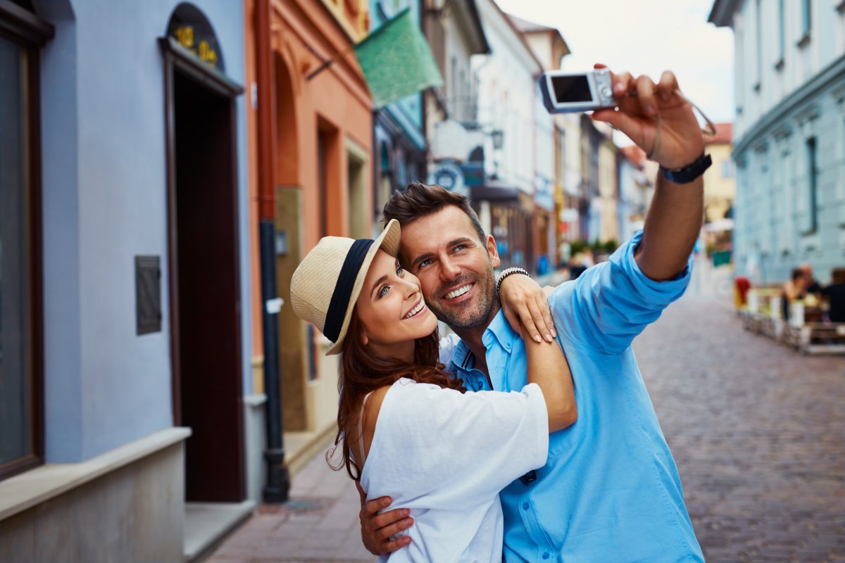Couple taking selfie on street.