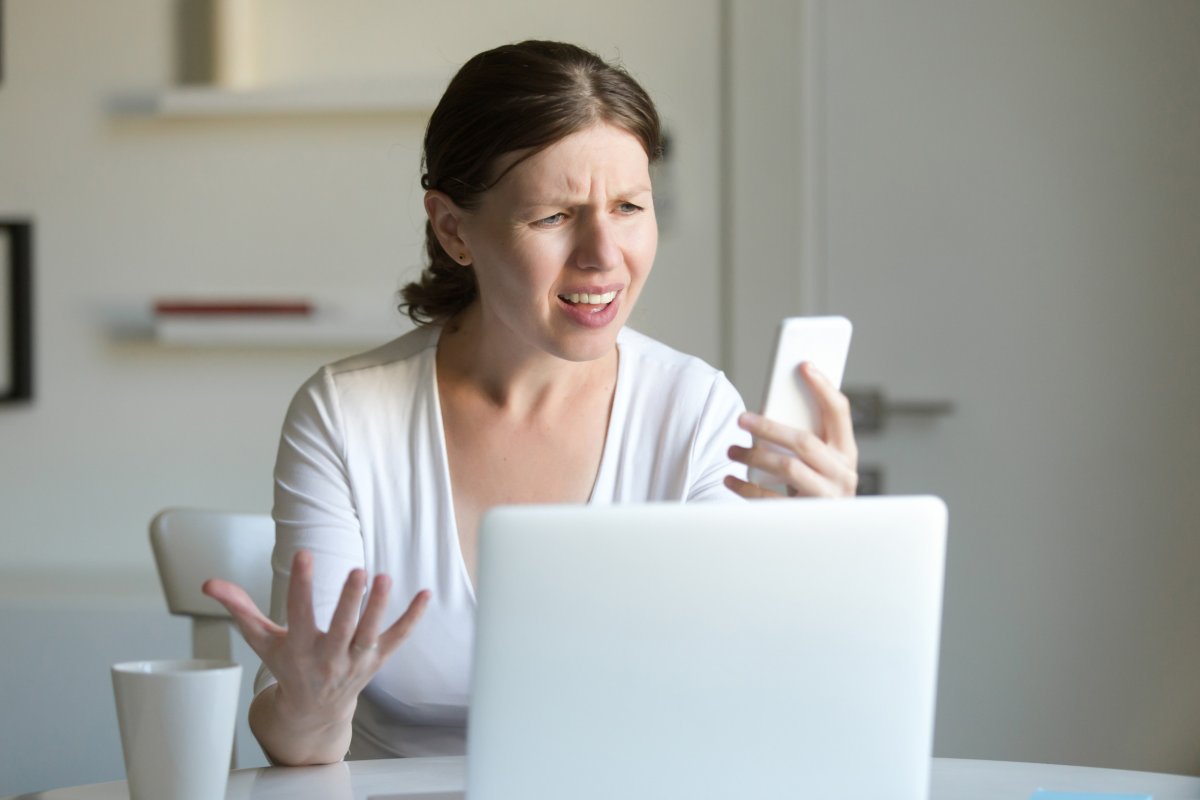 Woman looking at phone annoyed