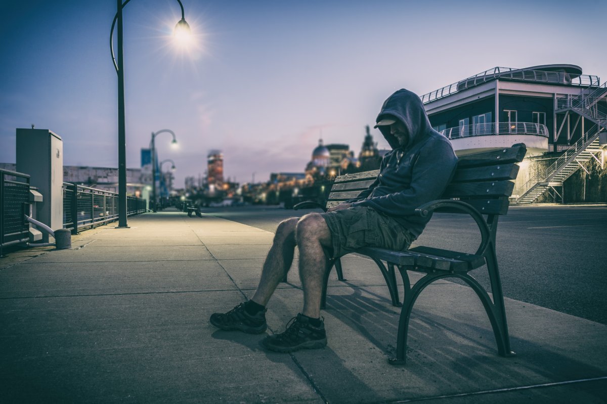 Man Sits On Bench Outdoors