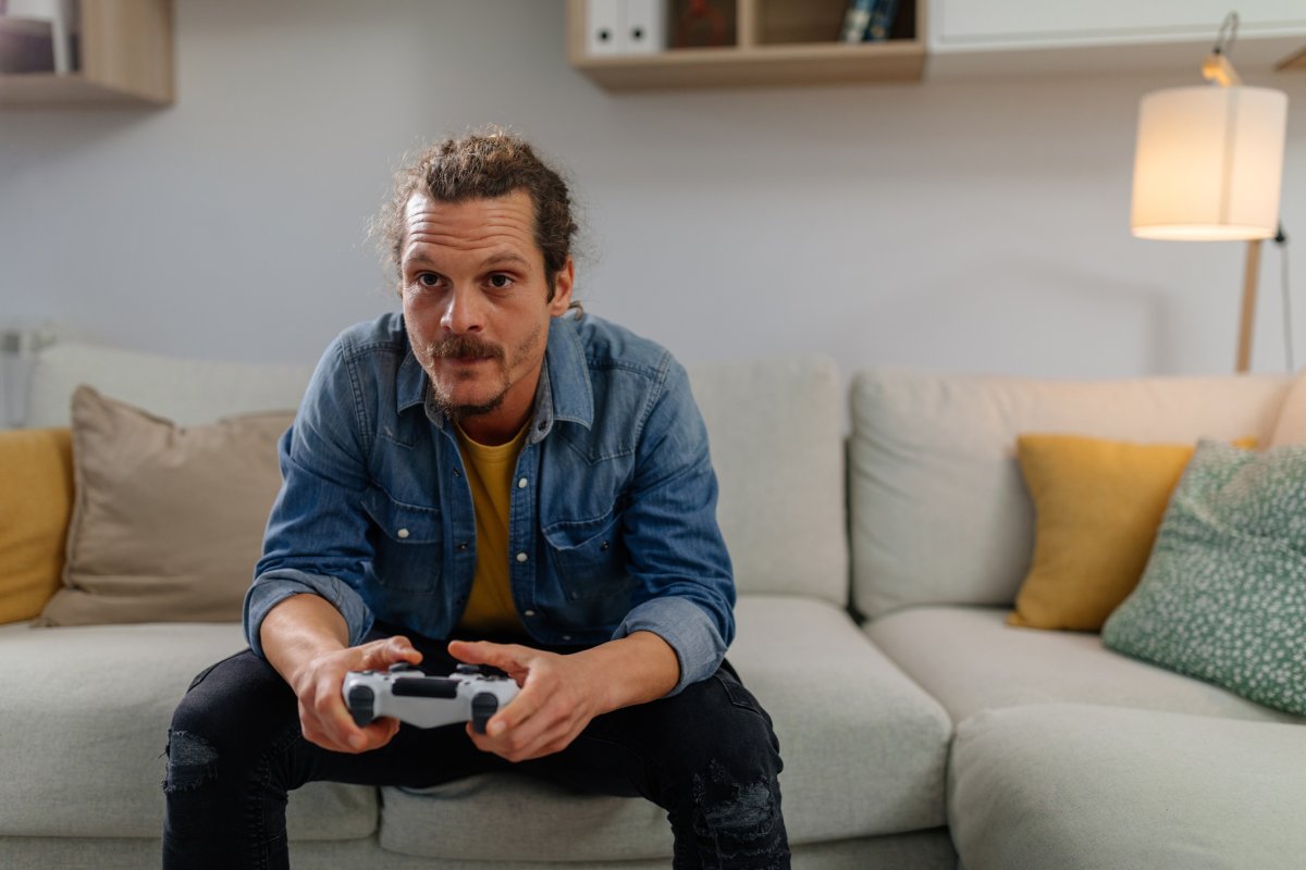 Stock image of man playing video games.