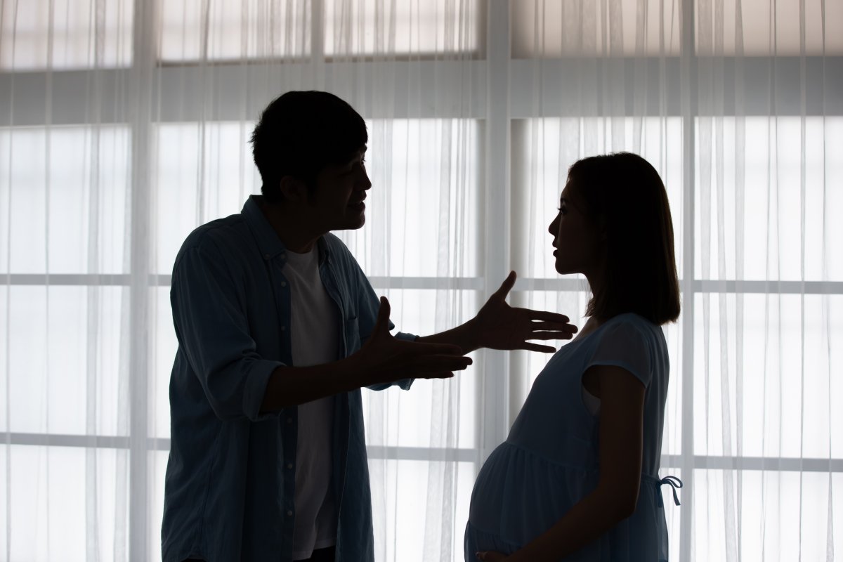 A pregnant couple argues at home