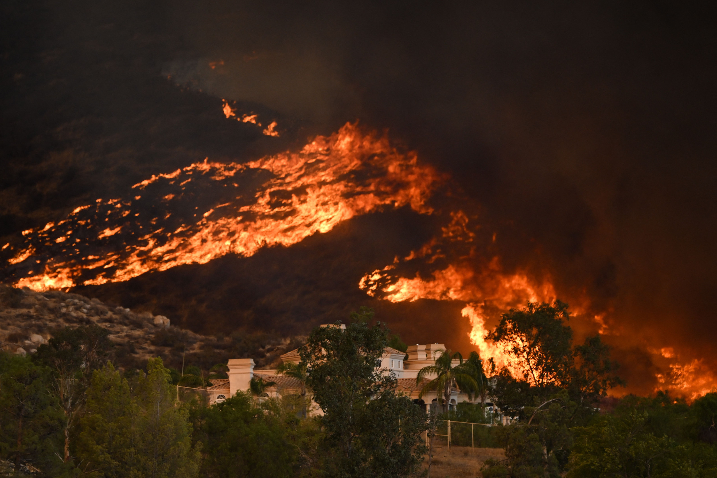 California wildfire scales mountain, puts “critical infrastructure” at risk