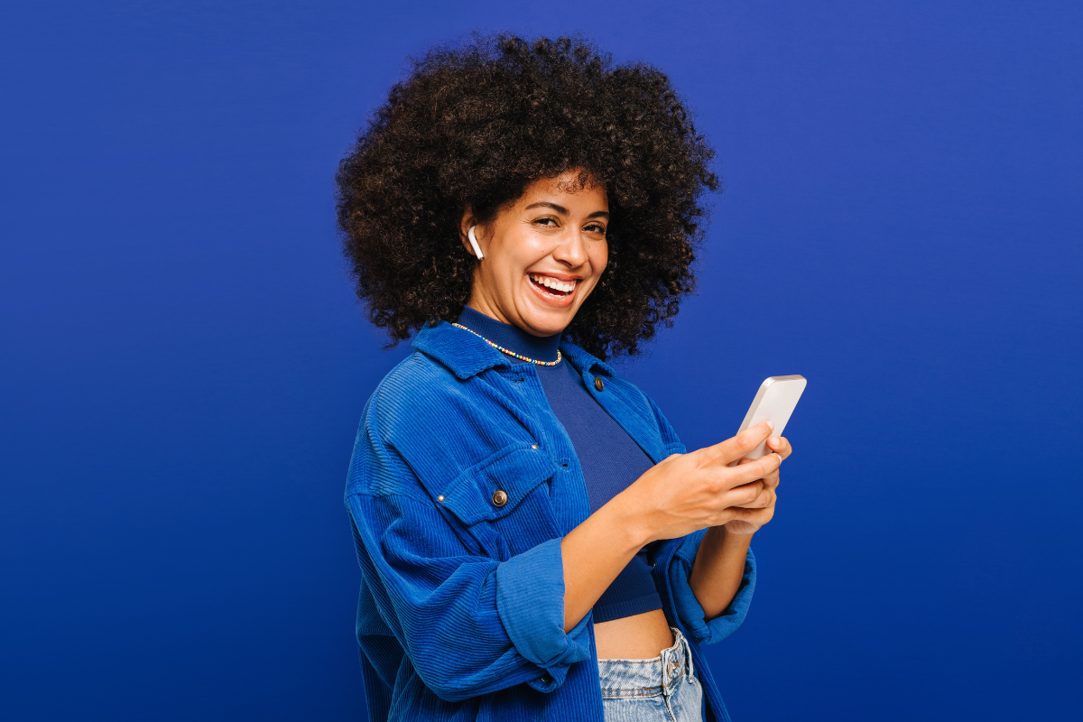 Woman holding mobile phone against blue background