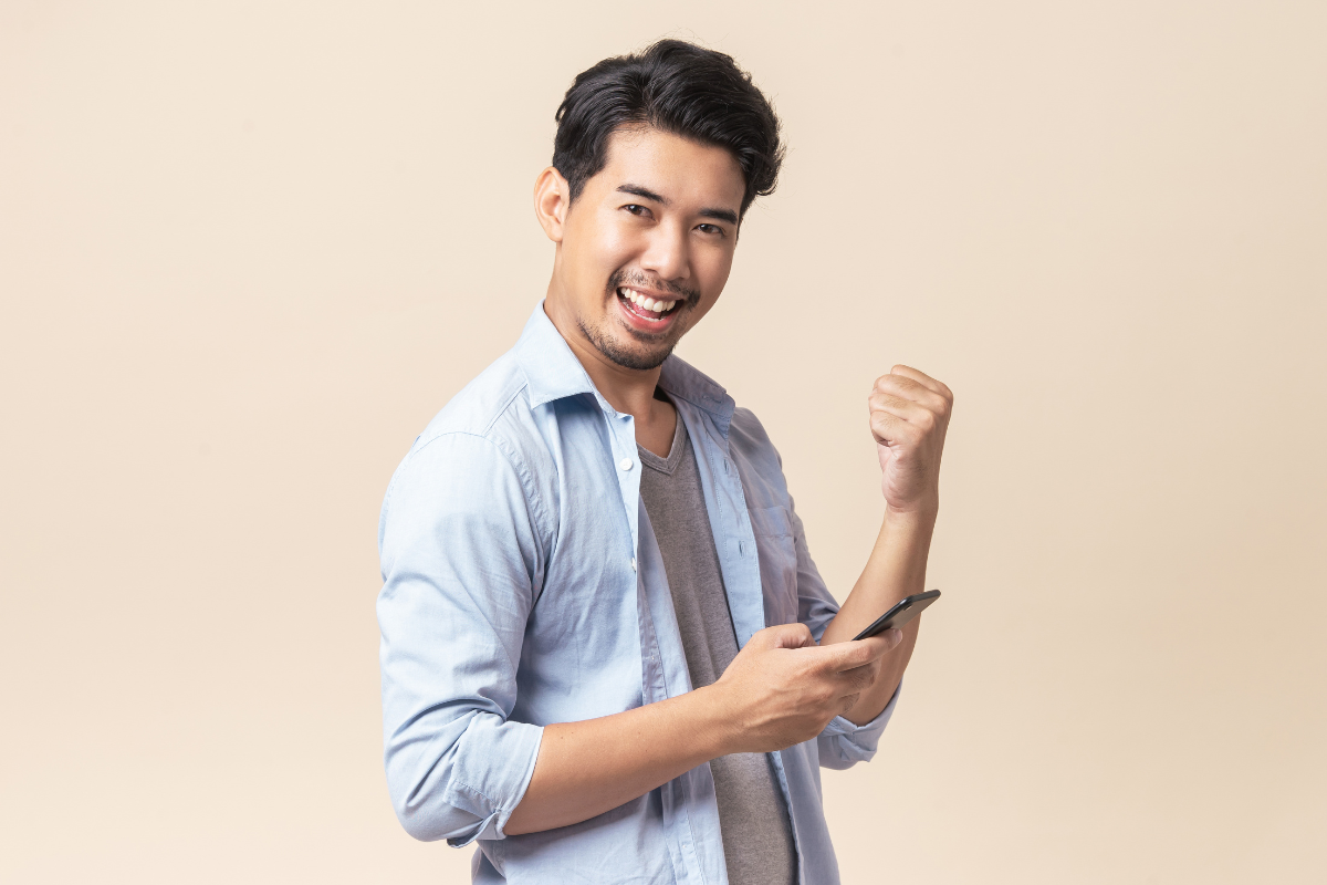 Man smiling and holding phone in one hand