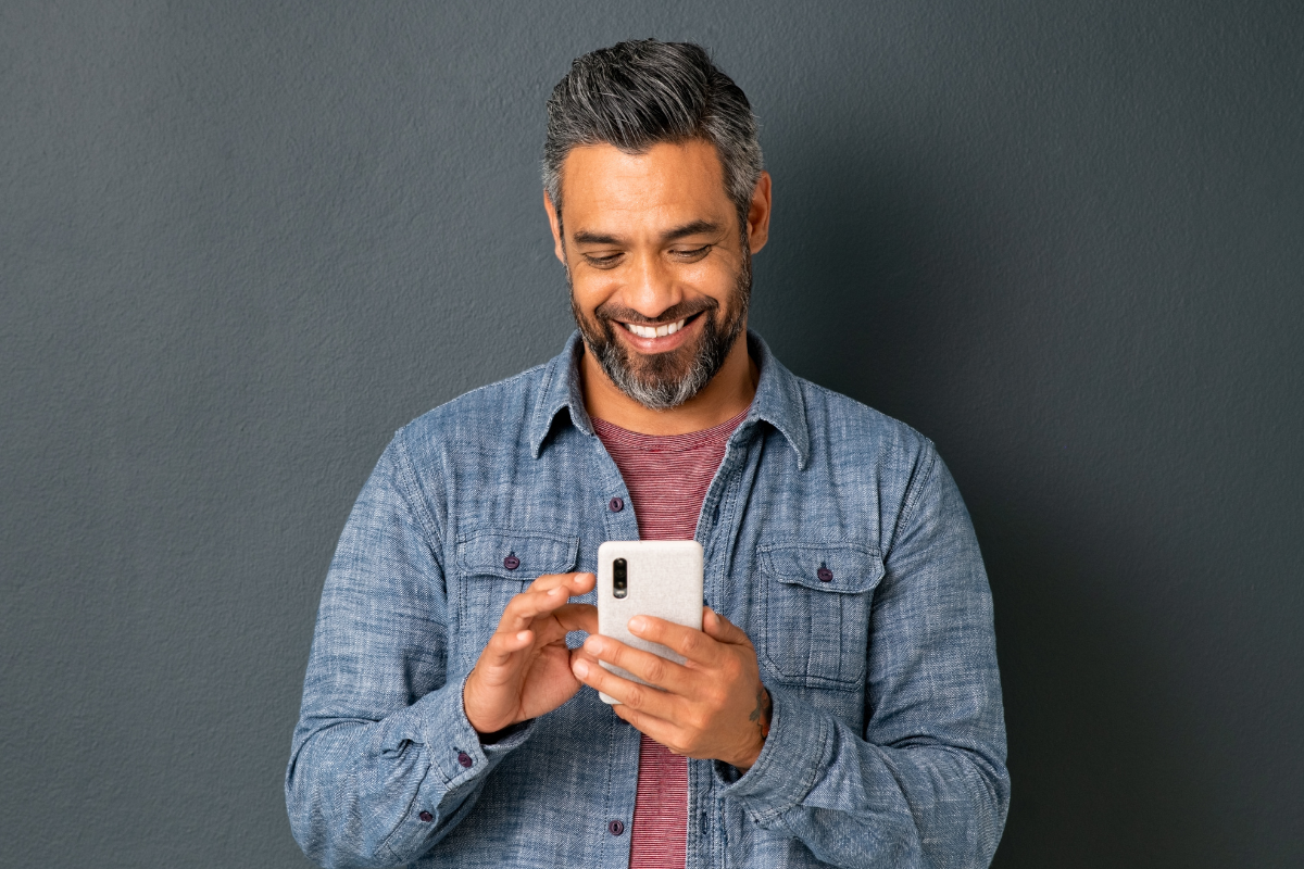 Man texts while smiling