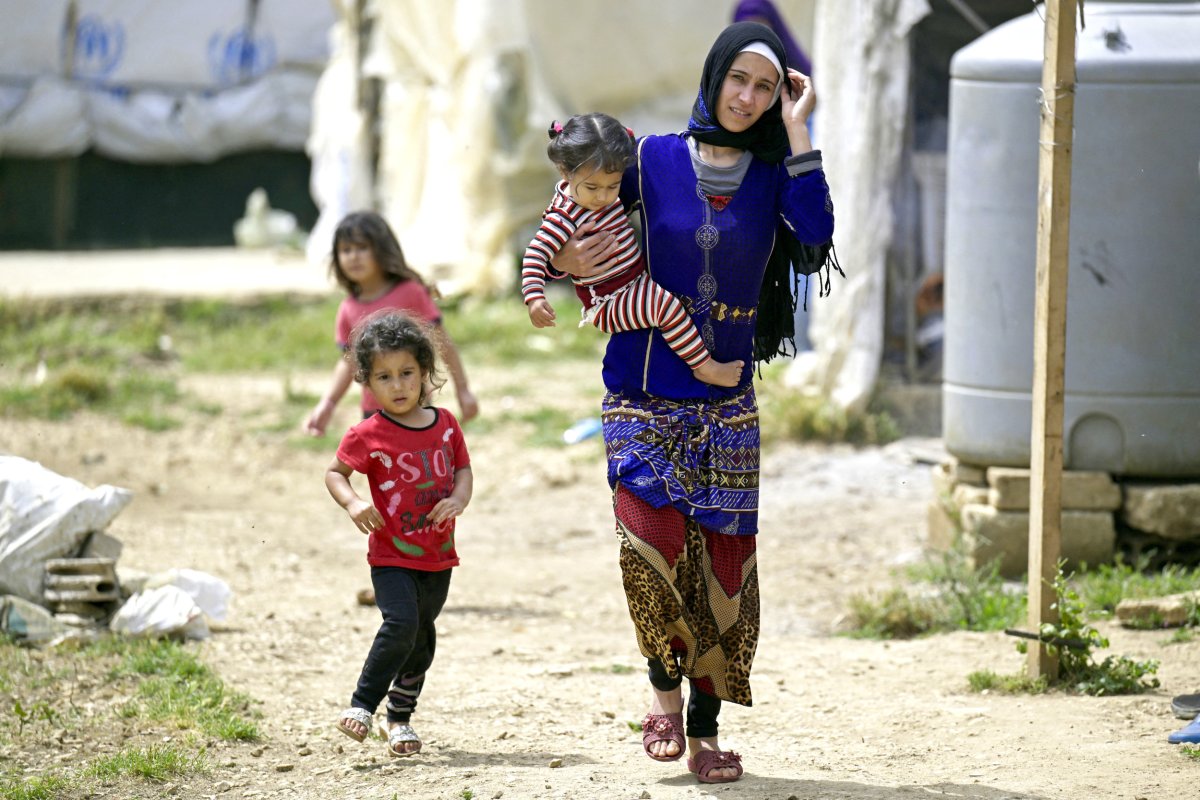 A Syrian refugee walks with her children