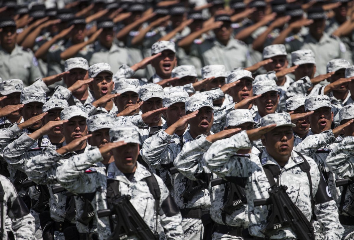 Mexican National Guard soldiers salute during a ceremony