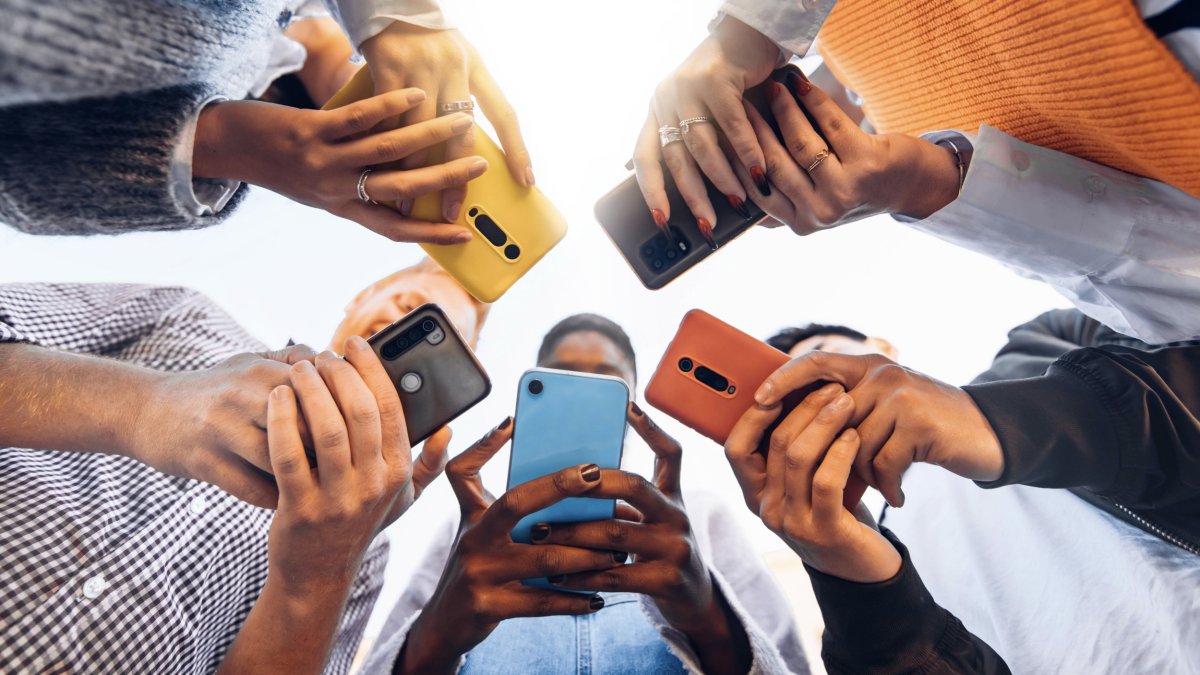 Stock image of teenagers using phones.