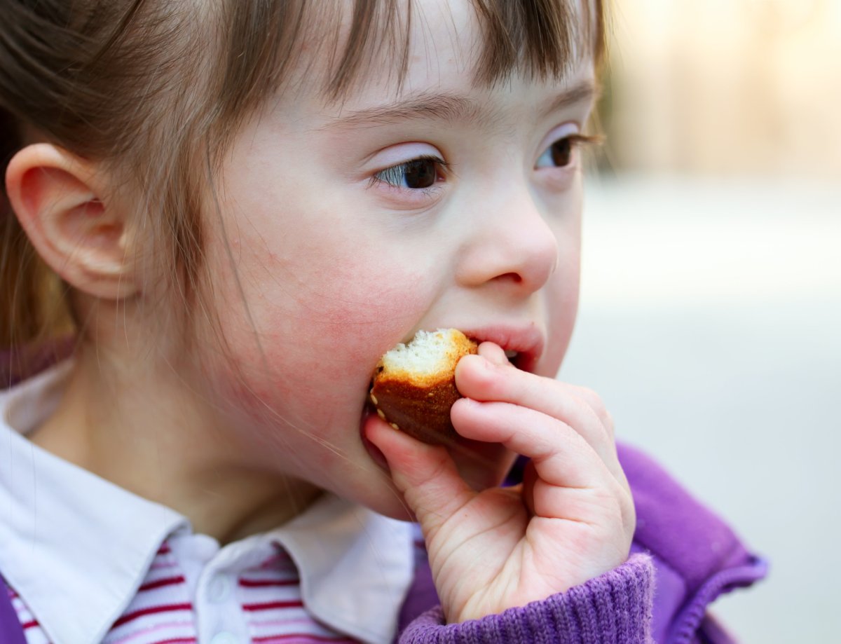 Portrait of a girl with Down syndrome eating