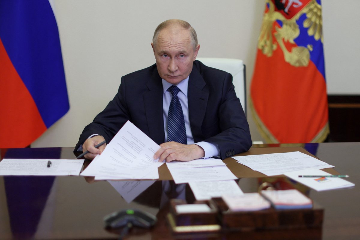 Russian President Vladimir Putin sitting at desk