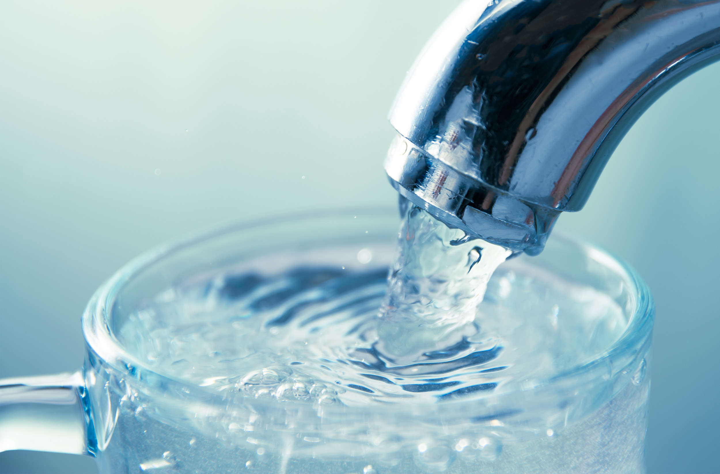 Water flowing from tap into glass