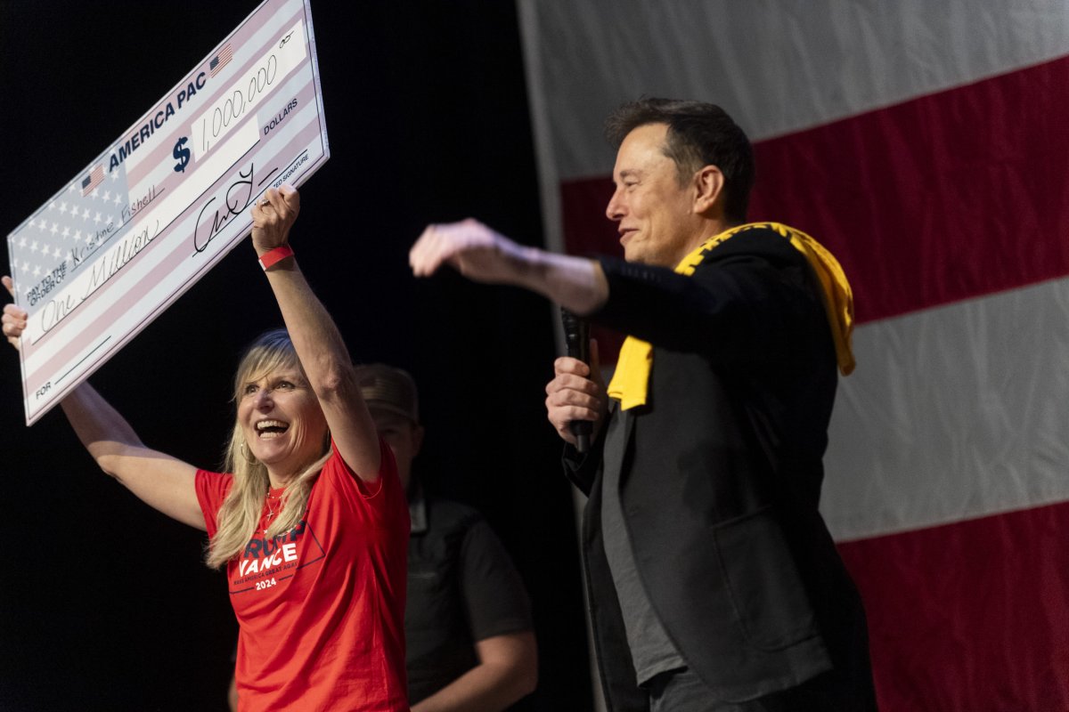 Elon Musk presents a check to Kristine Fishell.