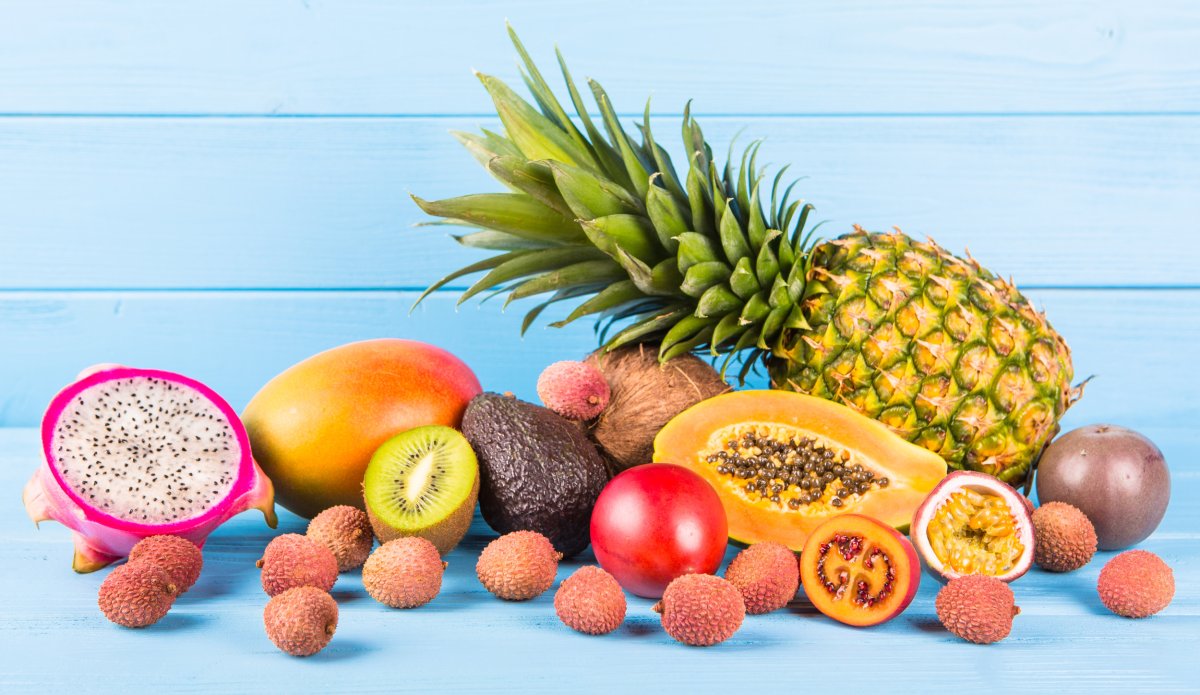 Fresh ripe fruits on blue wooden background