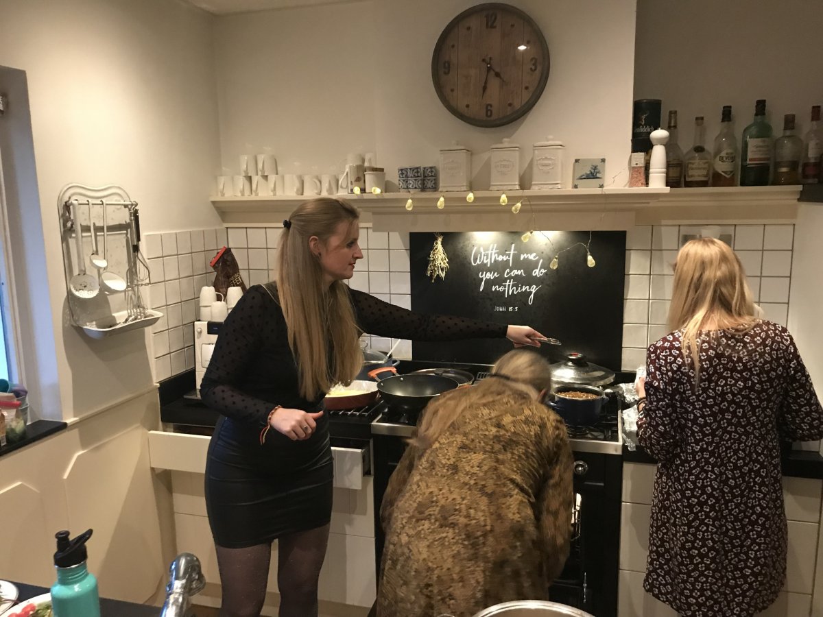 Three women cook in a kitchen