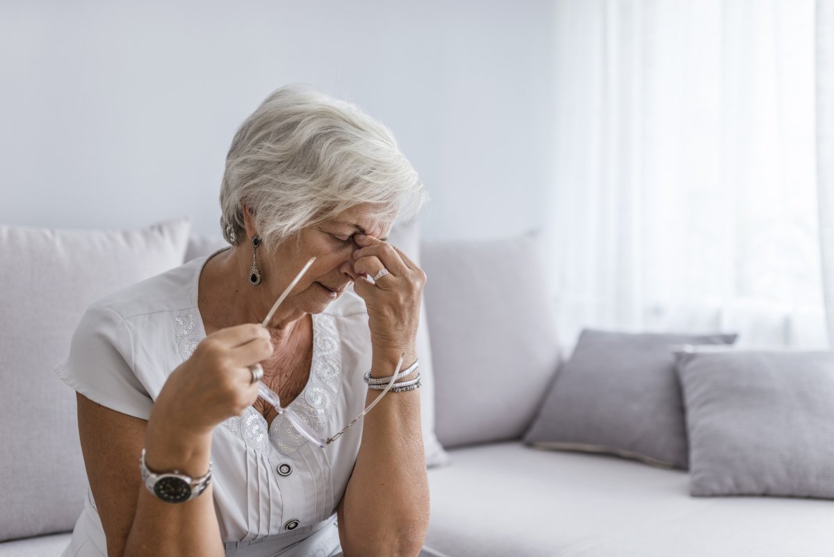 Elderly woman with headache at home