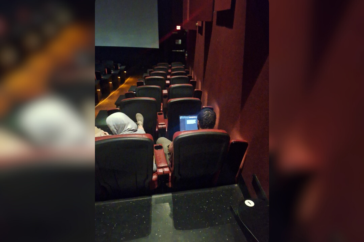 Man on laptop in cinema