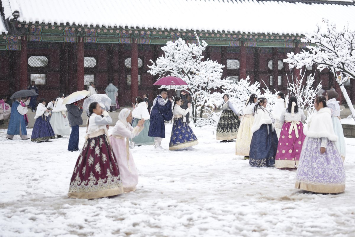 Pengunjung menikmati salju di Taman Gyeongbok