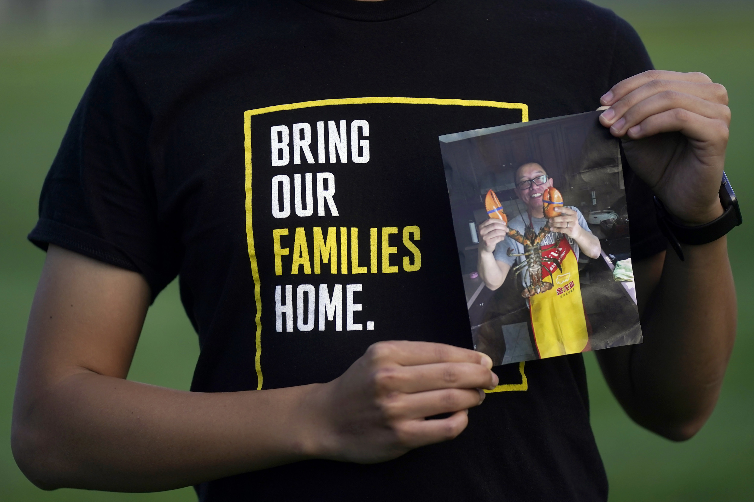 Harrison Li holds a photo of his father, Kai Li. (AP)