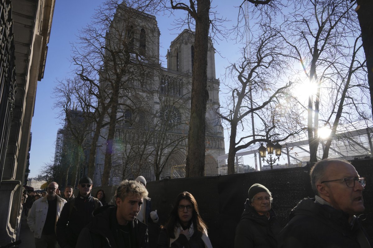 People walk past Notre Dame in Paris