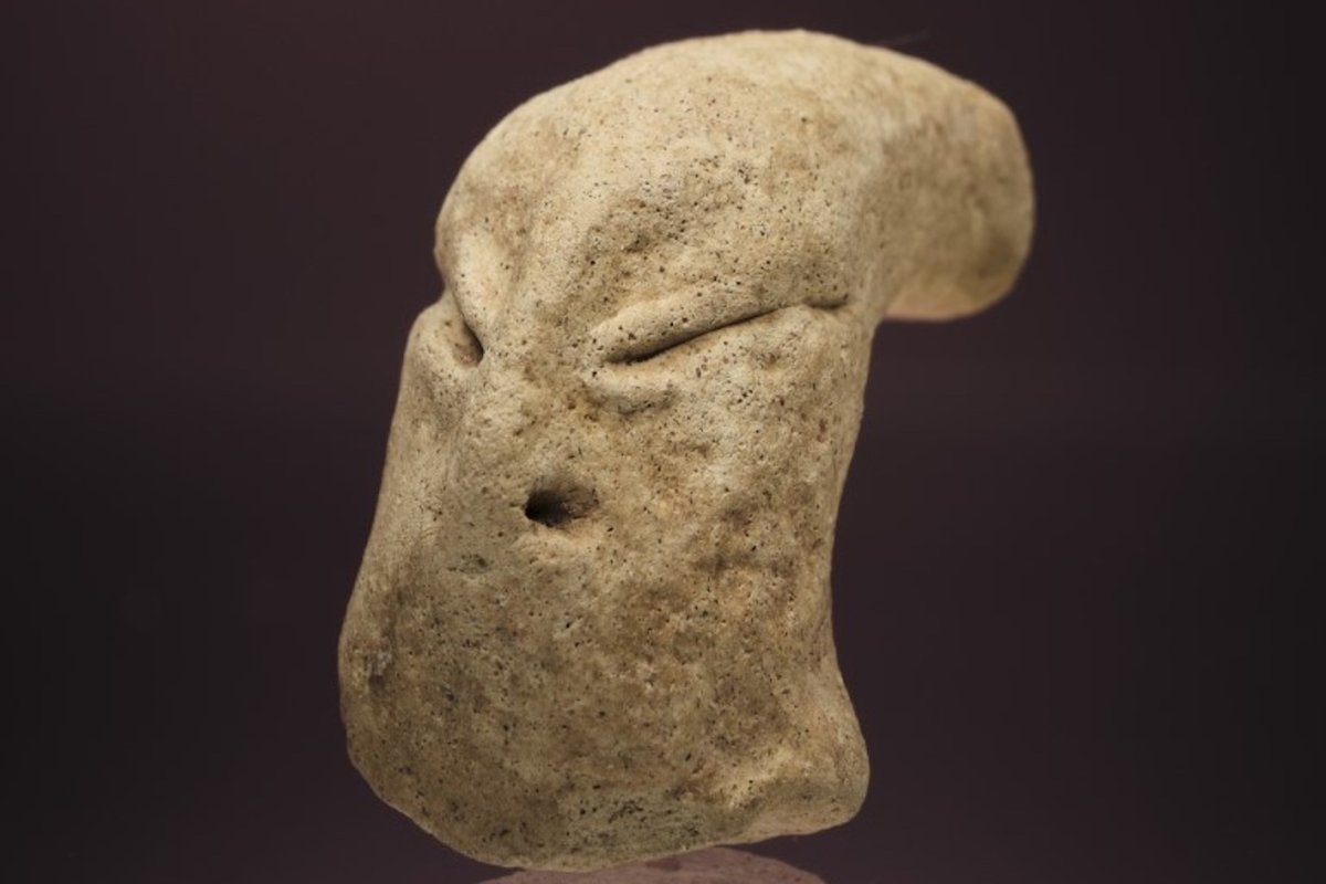 A prehistoric clay head figurine