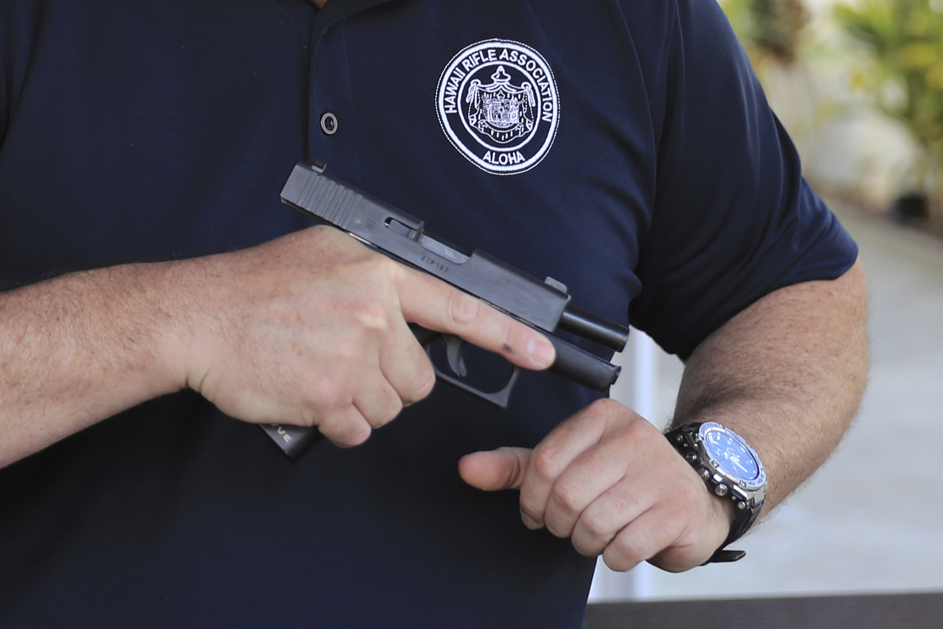 Kainoa Kaku, president of the Hawaii Rifle Association, checks one of his personal firearms. (AP Photo/ File)