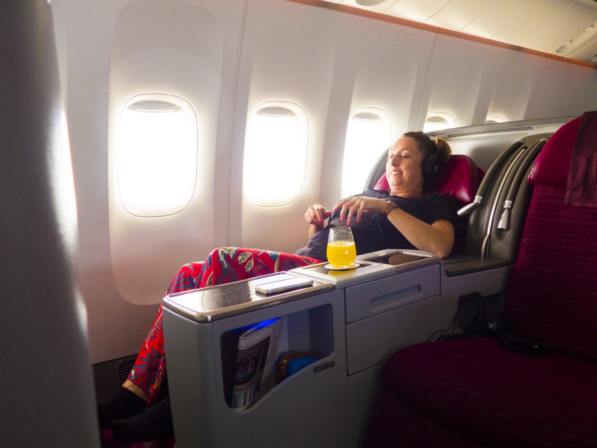 Passenger laying in business class seat.