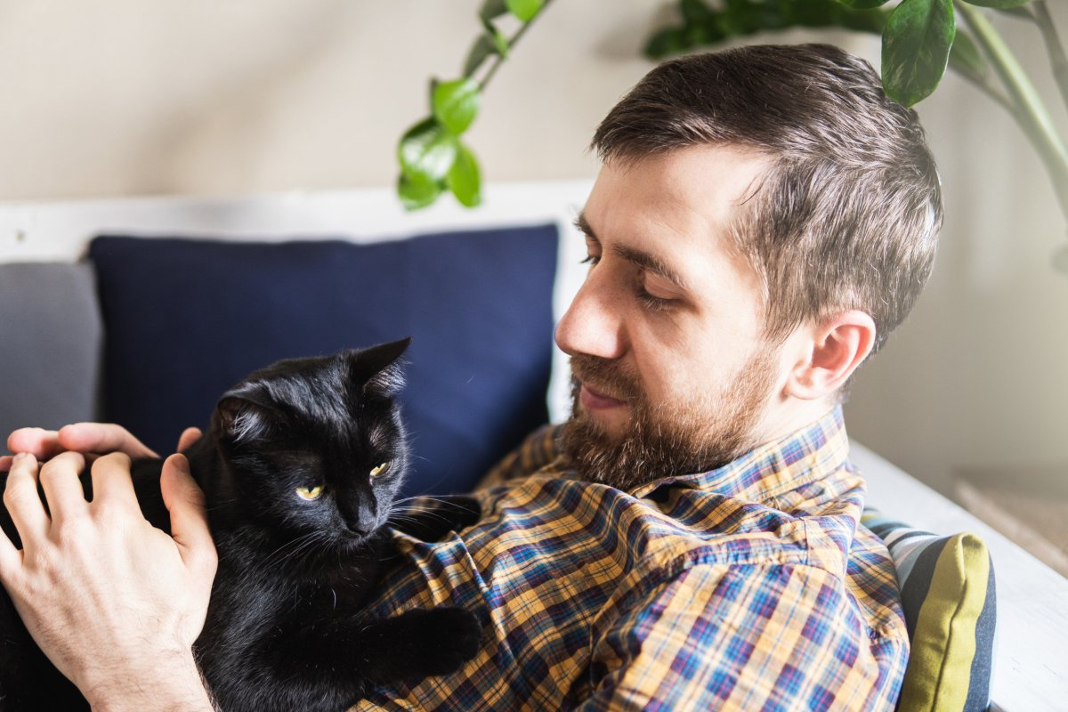 man cuddles cat