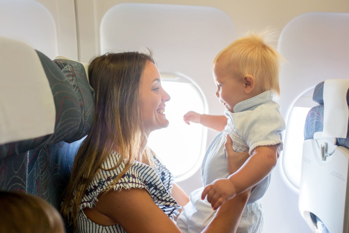 Woman holding baby on plane.