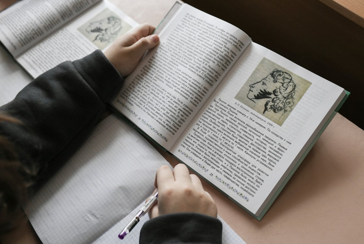 Student Reading Russian Textbook in School 