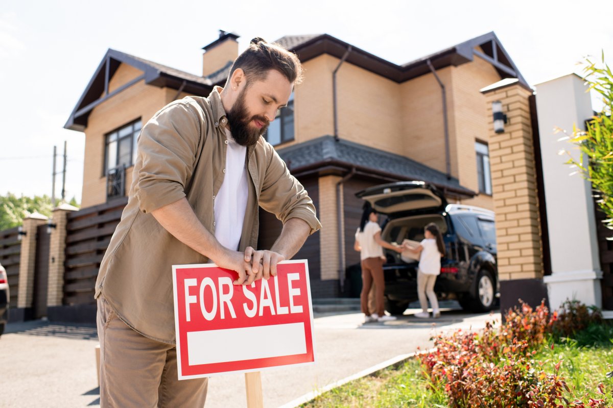 Homeowner putting for sale sign up