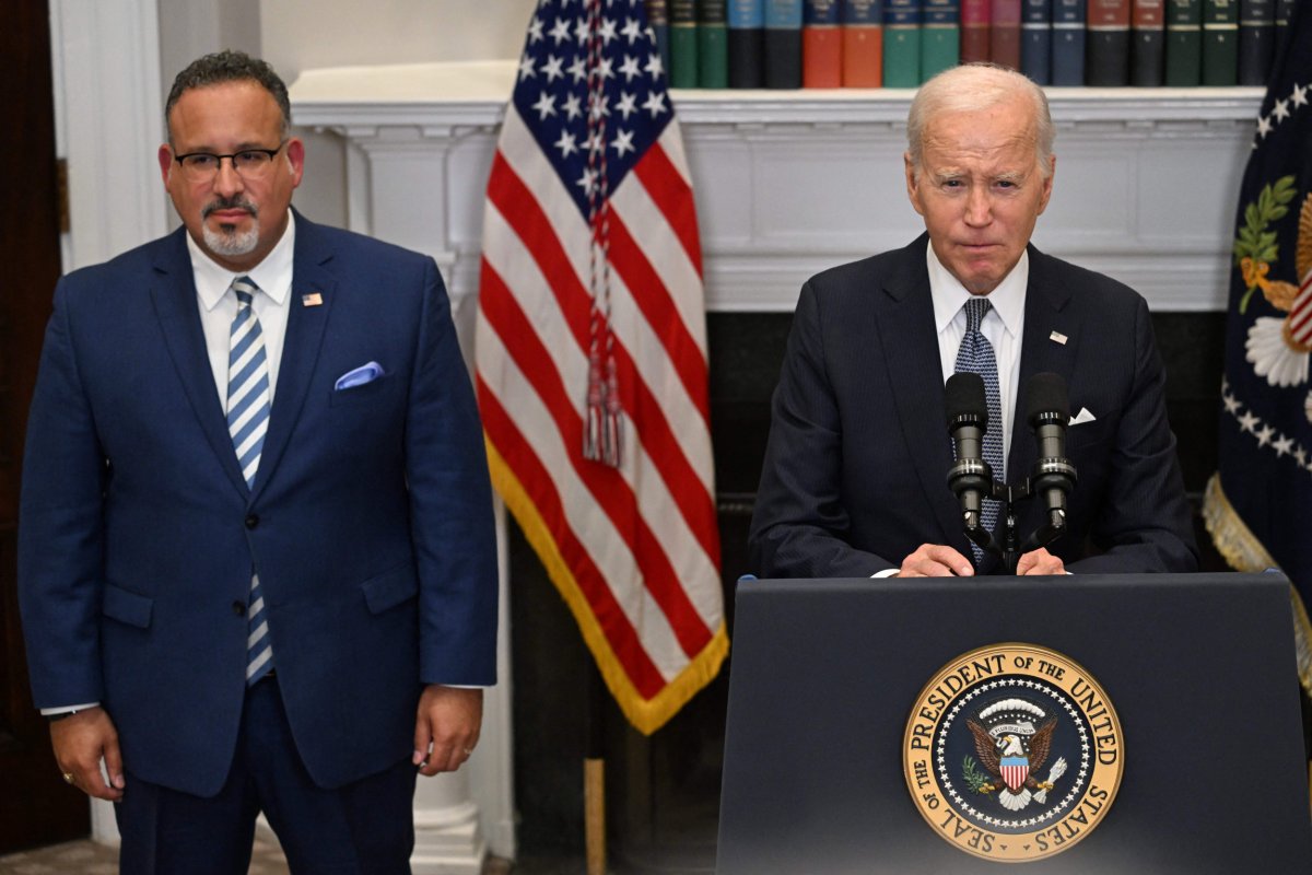 US President Joe Biden speaks beside Cardona