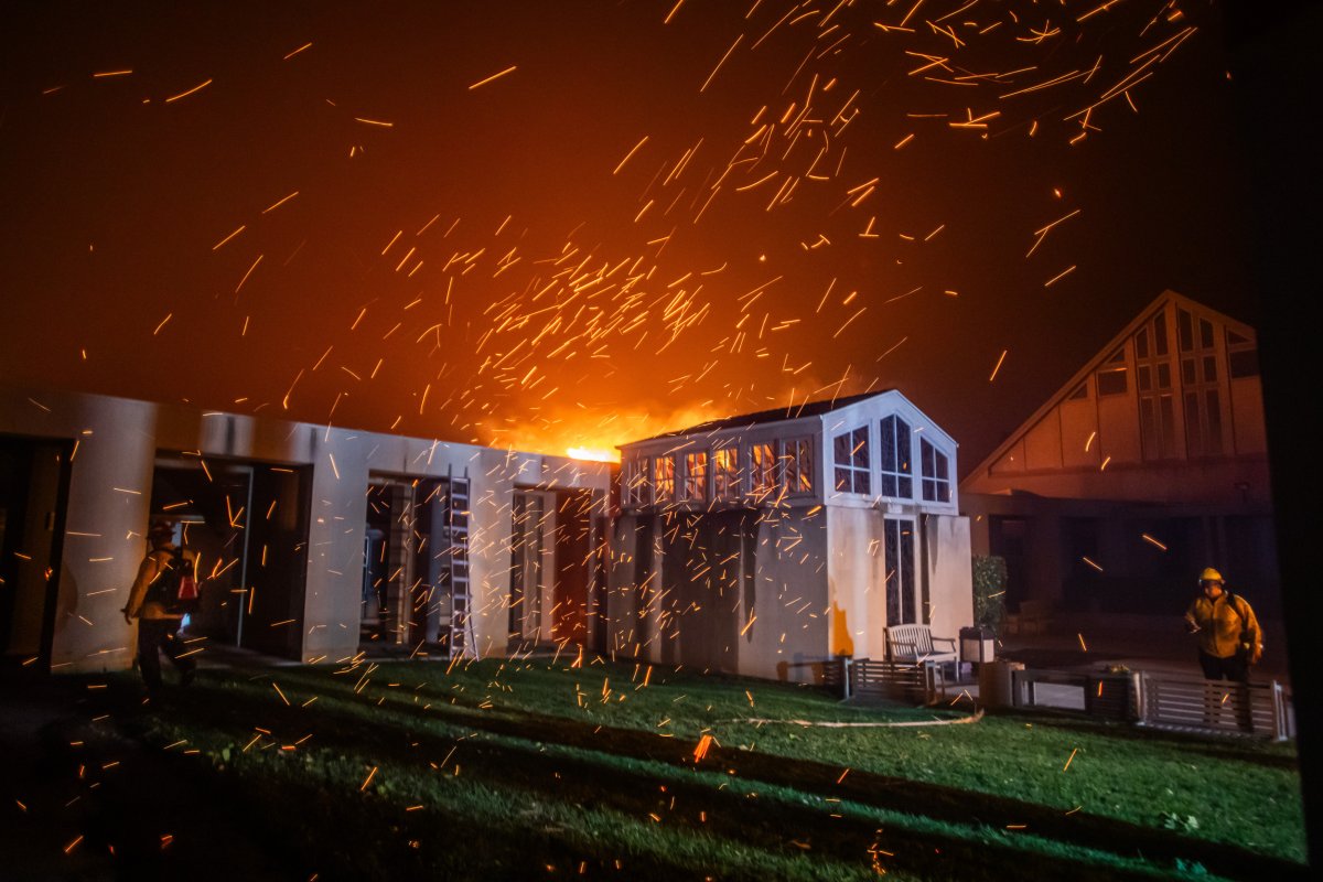 A firefighter watches flames from Palisades Fire