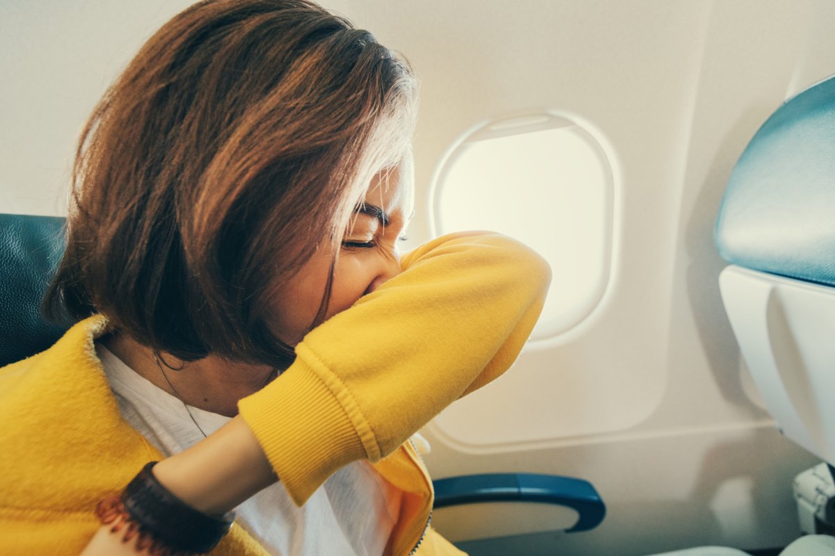 Woman sneezing on plane