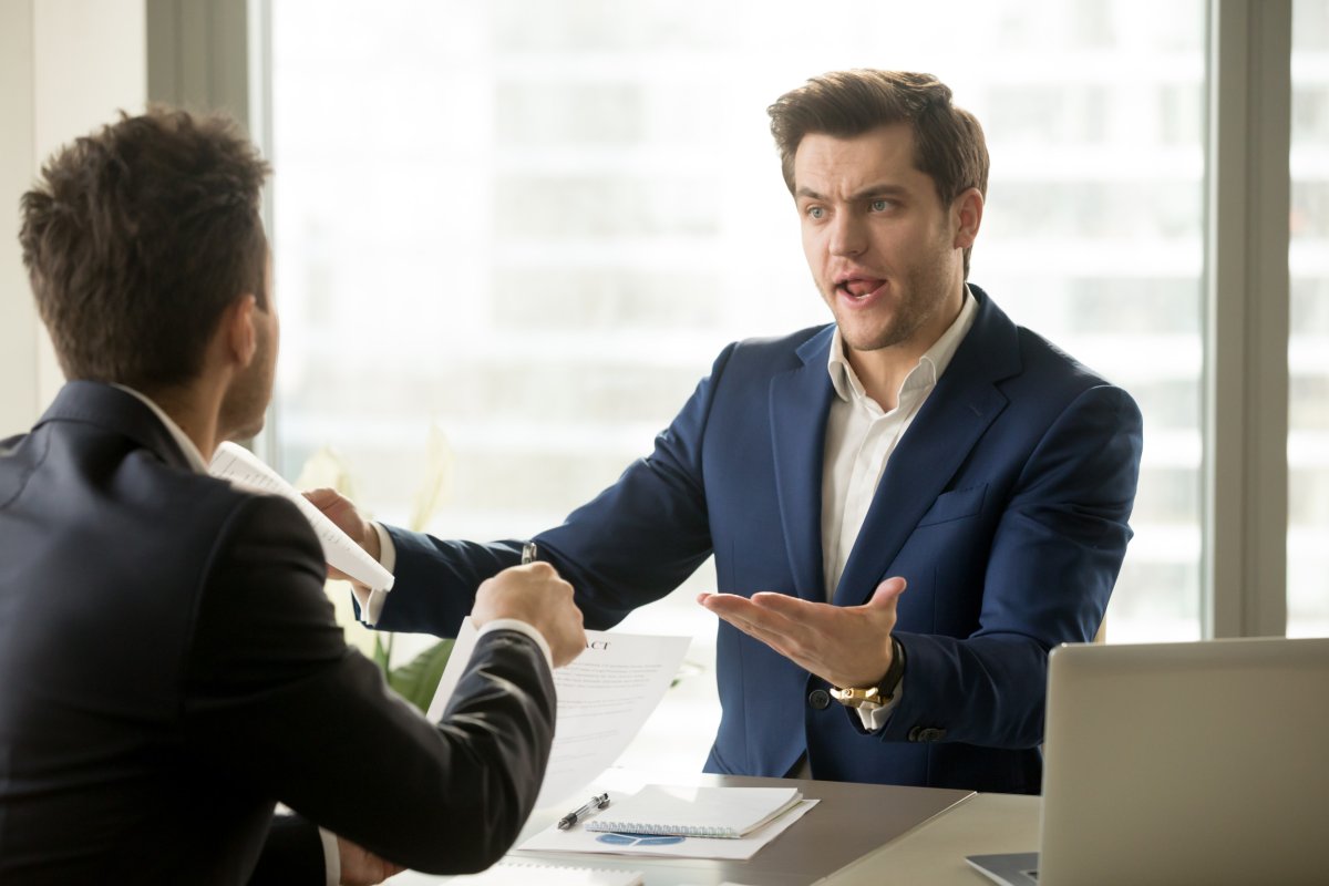 Manager looking upset talking to office worker.