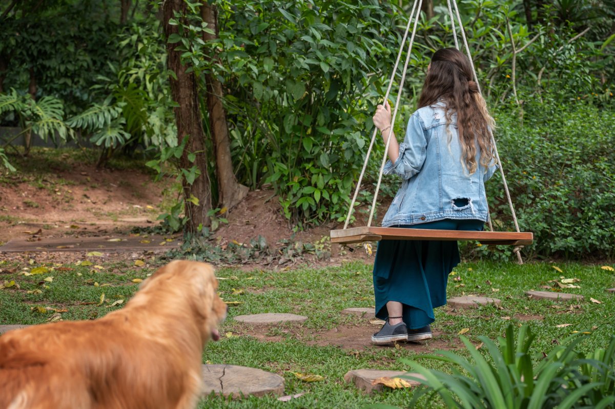 Golden Retriever Looks At Woman On Swing