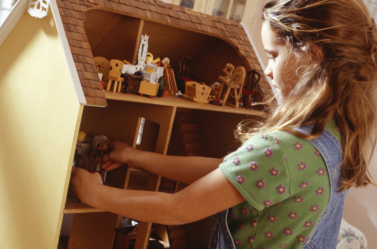 Girl plays with dollhouse