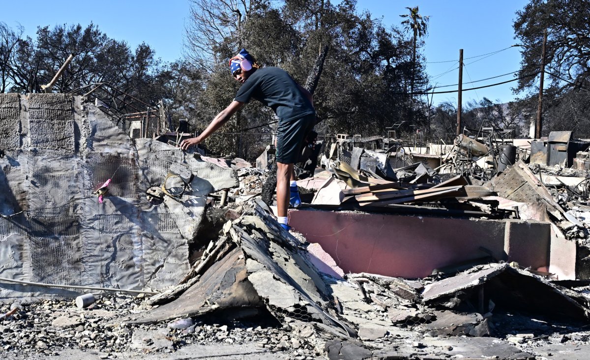 man climbs over rubble of family business