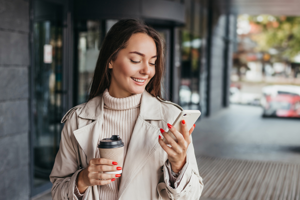 Woman Painted Nails Holds Coffee, Cell Phone