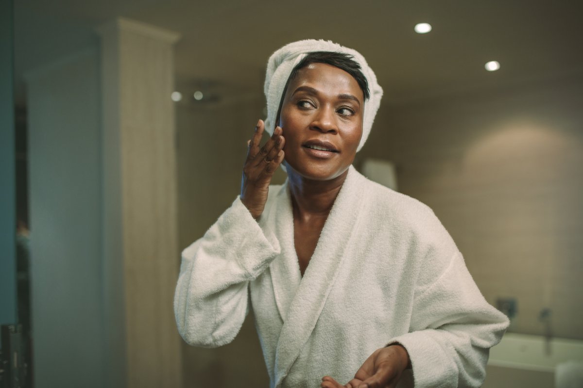 Stock image of woman applying face cream.