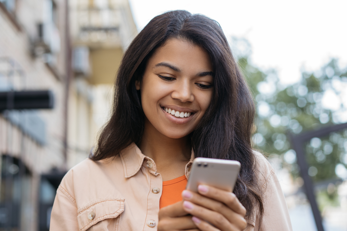 Woman Orange Shirt Outside Holds Mobile Phone