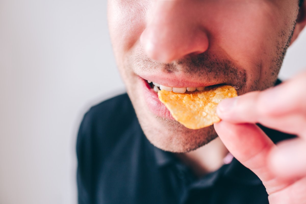 Stock of a man eating salty chips